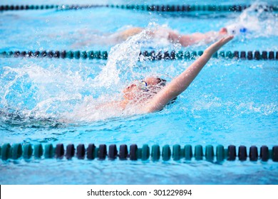 Motion blur image of a boy swimming backstroke in a race.  - Powered by Shutterstock