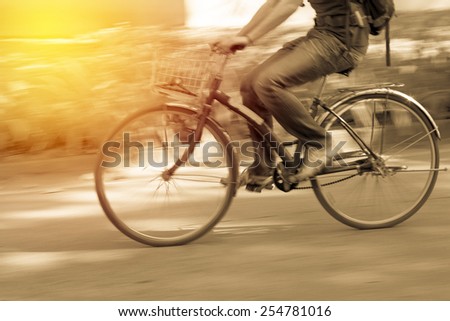 Motion blur. Male cycling bicycle. Vintage filter.