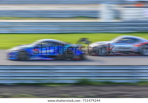 Motion Blur race car racing on\
speed track, Super car race on the international race\
track.