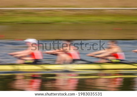 Motion blur of three collegiate women crew rowers in a race