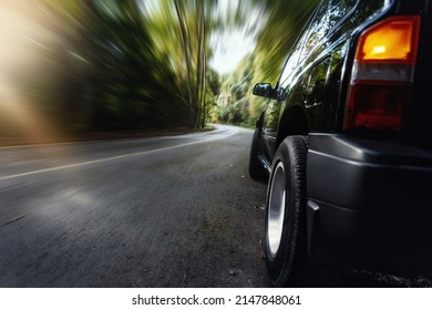 Motion Blur Of Trees Beside Country Road With Stoped Black SUV.
Adventure,travel And Holiday Trip Concept Background.