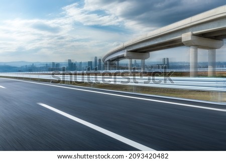Motion blurred asphalt highway and modern city skyline with buildings