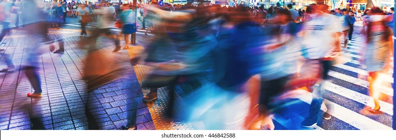 Motion blurred crowds converge at Shibuya Crossing, one of the busiest crosswalks in the world. Tokyo, Japan