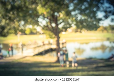 Motion Blurred Family With Kids Fishing Near Wooden Pier/dock At Lake Pond Outdoor. Free Community Event Sponsored By Neighborhood Association. Defocused People Fishing At The Lakeside Of Urban Park