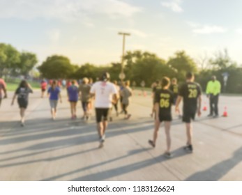Motion blurred group runners of all abilities at 5K Corporate Challenge race in Richardson, Texas, US. Fitness and healthy lifestyle concept. Athletes running on the roads. Urban sport event abstract