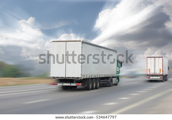 Motion blurred image of truck traffic on the highway\
in the sun