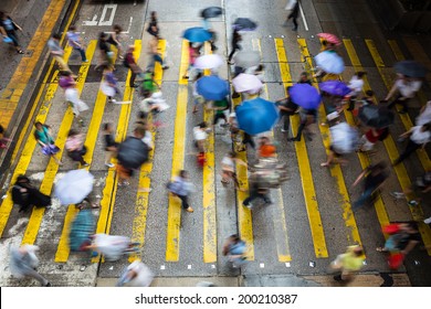 Motion Blurred Pedestrians Crossing Hong Kong Street In The Rain