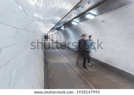 Motion Blurred People are Walking Under Thames River through Pedestrian Underground Pass Tunnel.