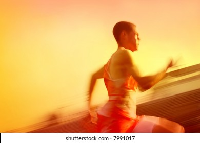 Motion Blurred Runner, Running Past The Stadium In A Race