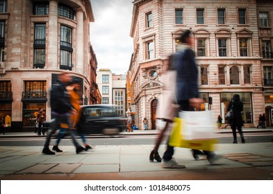 Motion blurred shoppers carrying shopping bags on Regent Street, London. 