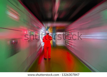 Motion blurred and Soft focus of Engineer checking and monitoring the electrical system in Electrical switch gear at Low Voltage motor control center cabinet room,Electrical selector ,button switch.