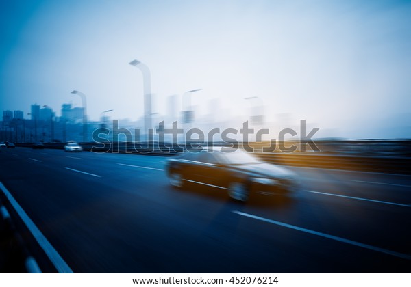 motion\
blurred traffic with city skyline\
background