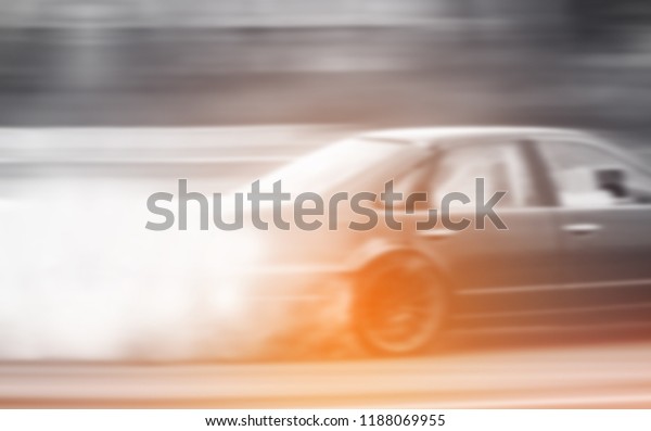 Motion blurry of Car\
drifting on track with grain, Sport car wheel drifting and smoking\
on track.