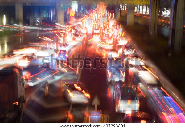 Motion cars\' lights and\
street lamps capture while driving on highway road at night.  Use\
for background