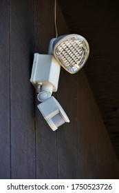 A Motion Detector Spotlight Is Mounted On The Side Of A Residential Home. 