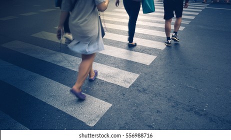 Motion Of Pedestrian Zebra Crossing Or Crosswalk In Asia. Feet Of The Pedestrians Crossing On City Street Closeup.