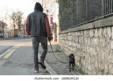 Motion Photo - Time Lapse Simulation. The Boy With The Small Dog Walks On The City Street. 