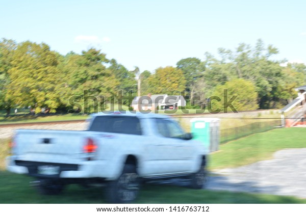 Motion picture of a
parked truck taken in a moving car while approaching train tracks
on a college campus.