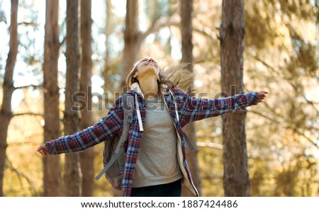 motion portrait freedom woman looking up with open arms in forest, enjoying nature scenery. Concept people and nature, adventure