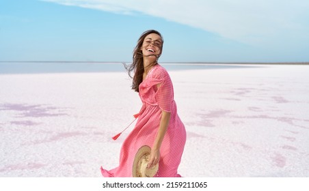 Motion portrait happy laughing woman in pink dress playful having fun on desert beach of salt pink lake. Ukraine Sivash lake - Powered by Shutterstock