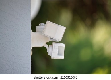 Motion sensor with light detector mounted on exterior wall of private house as part of security system - Shutterstock ID 2250526091