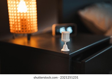 Motion sensor on the bedside table. Smart home automation. Room interior. Modern home automation solution. Bedroom.