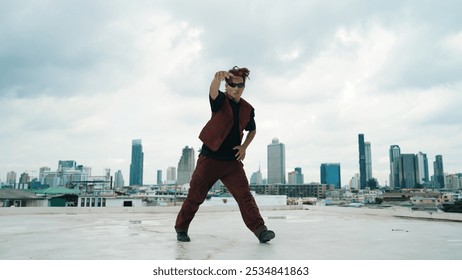 Motion shot of B-boy dance performance by professional street dancer at rooftop with sky scrapper, city view. Attractive asian hipster show energetic footstep. Outdoor sport 2024. Hiphop. - Powered by Shutterstock