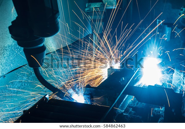 The Motion Welding robots in a car\
factory with sparks, manufacturing, industry,\
factory