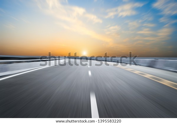 Motion-blurred highway in dusk\
clouds