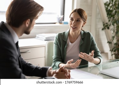 Motivated Diverse Caucasian Colleagues Or Partners Talk Discuss Business Ideas At Meeting In Office, Confident Female Employee Speak At Interview With Employer Or Boss, Make Good First Impression