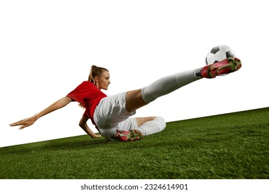 Motivated female athlete, young girl, football player kicking ball in motion on field grass against white background. Concept of professional sport, action, lifestyle, competition, hobby, training, ad - Powered by Shutterstock