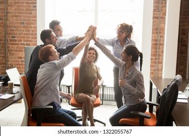 Motivated happy diverse business office people employees group give high five with coach mentor engaged in team win result promise support integrity in teamwork, celebrate cooperation reward concept