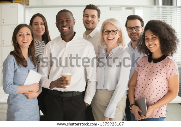 Motivated international multi-ethnic company\
members aged and young corporate team photographing posing for\
camera, successful staff portrait concept of growth in career\
leadership and racial\
equality