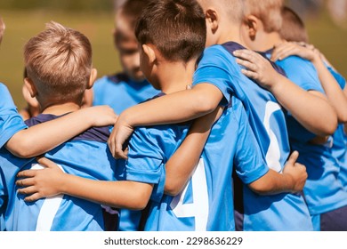 Motivated kids in soccer team cheering on court. Players huddling in a circle on the field. Coach talking to a group of soccer players. Happy football team with their coach - Powered by Shutterstock