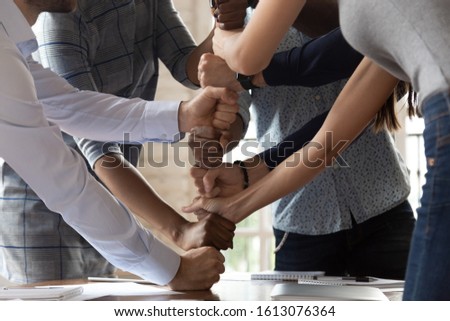Motivated multiethnic employees involved in teambuilding activity at office meeting, diverse young colleagues stack fists engaged in motivational training show unity, support and team spirit Foto stock © 