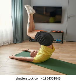 Motivated Sportive Bald Man Doing Lower Abs Exercise On Fitness Mat, Doing Leg Raises While Working Out In Living Room At Home. Healthy Lifestyle, Stay Home Concept