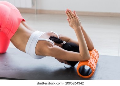 Motivated Sporty Woman Training On Mat Indoor Winter Day, Using Foam Roller Massager For Relaxation, Stretching Spine Muscles, Doing Fascia Exercise. Health Care, Workouts Routine