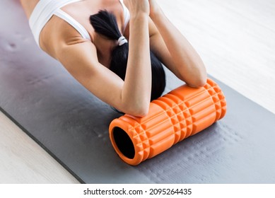 Motivated Sporty Woman Training On Mat Indoor Winter Day, Using Foam Roller Massager For Relaxation, Stretching Spine Muscles, Doing Fascia Exercise. Health Care, Workouts Routine