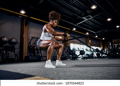 Motivated Strong Sporty Lady Performing The Alternating Waves Exercise With Battle Ropes At The Gym