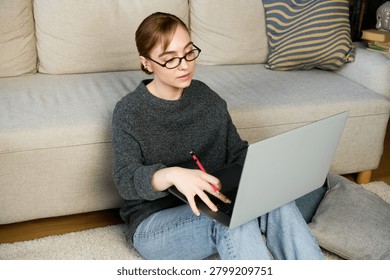 A motivated student types notes and absorbs knowledge in her cozy workspace.