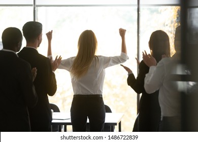 Motivated Successful Female Executive Business Woman Leader Get Team Applause Raise Hands Standing At Window Celebrating Professional Victory Triumph And Corporate Success Concept, Rear Back View