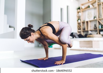 Motivated Woman In Track Suit Standing In Bakasana Pose Breathing And Enjoying Recreation At Home Apartment, Female Practice Yoga Feeling Inspiration And Balance In Asana Keeping Body Shape