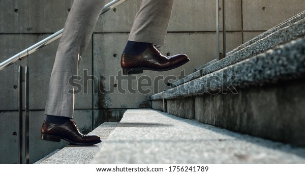 Motivation and\
challenging Concept. Steps Forward into a Success. Low Section of\
Businessman Walking Up on\
Staircase