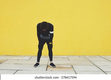 Motivation to run, exhausted runner resting tired after training outdoors, athletic jogger with muscular body taking break in city road, fitness and healthy lifestyle concept
