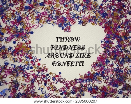 Motivational and inspirational wording. THROW KINDNESS AROUND LIKE CONFETTI written on a white paper. With blurred style background.