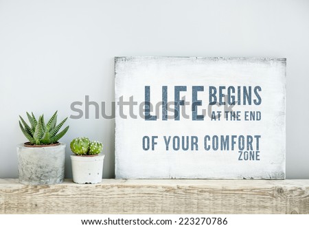 motivational poster quote LIFE BEGINS AT THE END OF COMFORT ZONE. scandinavian or american style room interior.