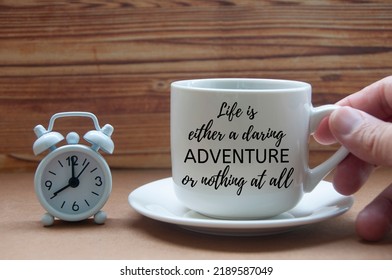 Motivational Quote On Coffee Cup - Life Is Either A Daring Adventure Or Nothing At All. Motivational And Inspirational Concept.