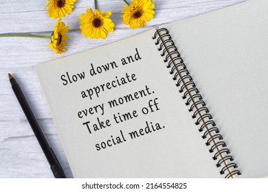 Motivational Quote On Note Book With Sunflowers On Wooden Desk - Slow Down And Appreciate Every Moment, Take Time Off Social Media.