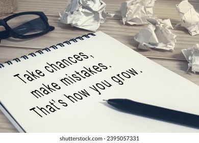 Motivational quote on notepad with pen on wooden desk . - Shutterstock ID 2395057331