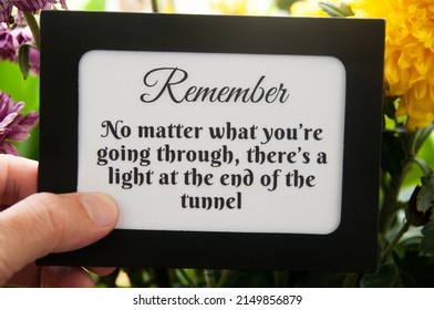 Motivational quote text on notepad - No matter what you're going through, there's a light at the end of the tunnel. Motivational concept